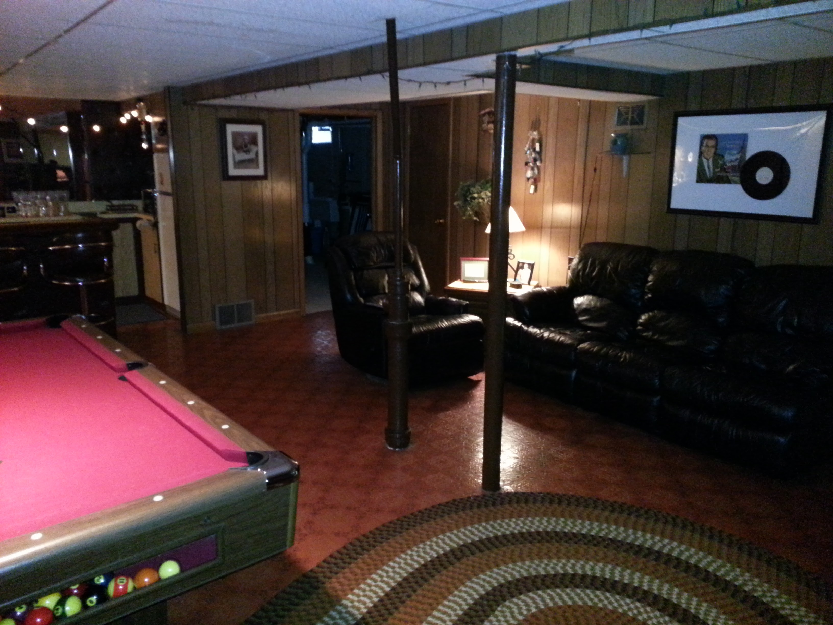 Basement before — dark wood paneling, old bar, dim lighting